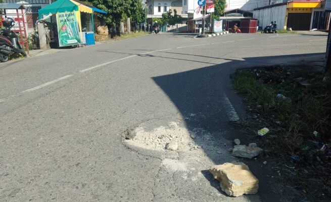 Lubang di Persimpangan Jalan Irian Ancam Keselamatan Pengendara